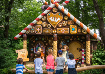 Kinder stehen vor Lebkuchenhaus im Familypark im Burgenland